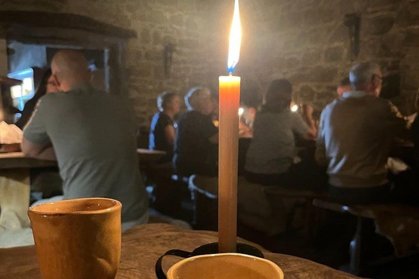 Une bougie sur une table dans un restaurant, avec des clients qui dînent en arrière-plan. 4
