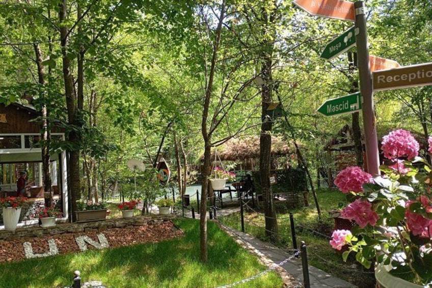 Un jardín con un pabellón, un sendero y un cartel con indicaciones. 3
