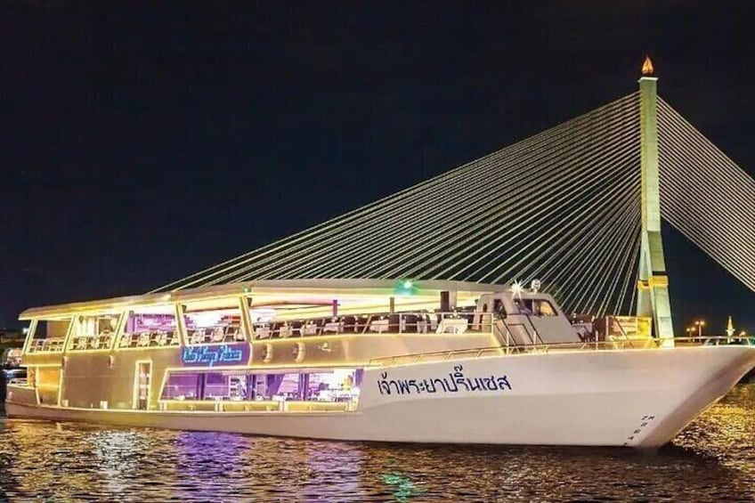 A boat with 'Lighthouse Point' written on it, docked near a modern bridge at night. 1