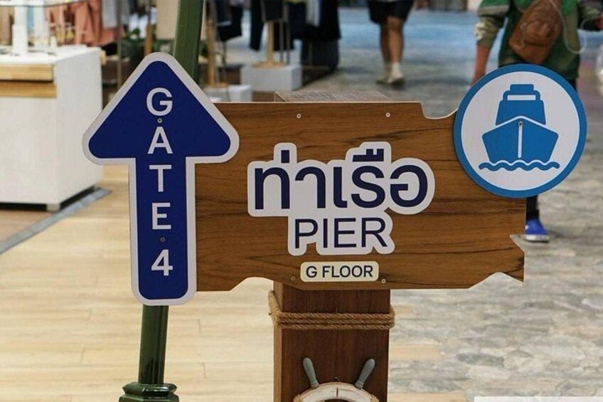 Ein hölzernes Schild mit einem blauen Pfeil, der nach oben zeigt, mit der Aufschrift 'GATE 4' und einem Symbol für einen Steg. 3