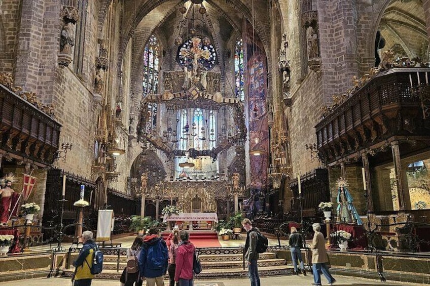 Een kathedraalinterieur met hoge gewelfde plafonds, glas-in-loodramen en religieuze beelden. 2