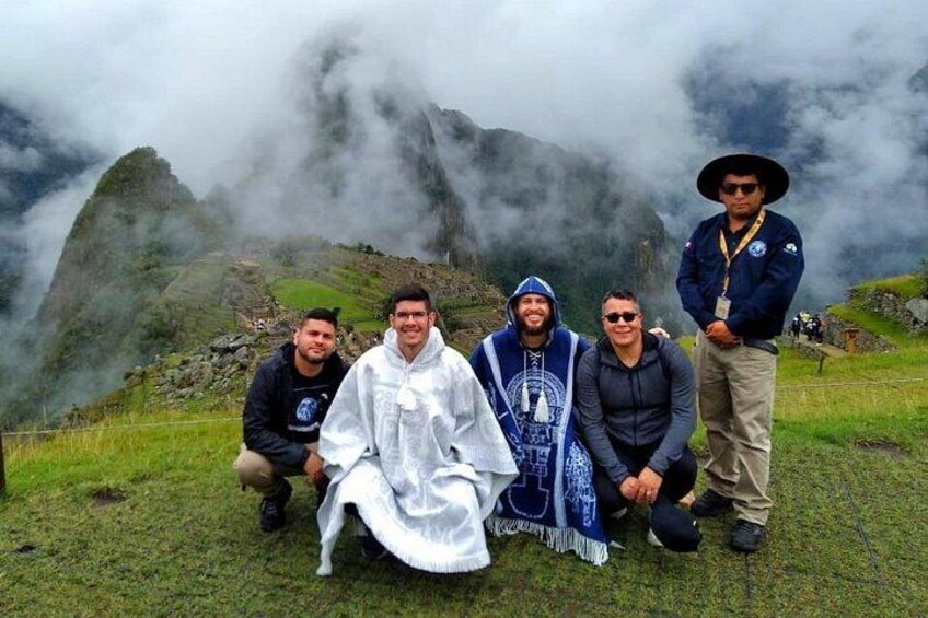 Un grupo de personas en una colina cubierta de hierba, con montañas brumosas al fondo. 3