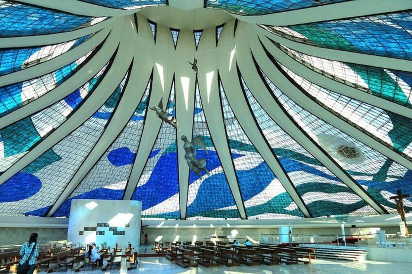 Un interior arquitectónico moderno con un diseño de techo único, que presenta una escultura central y un suelo con motivos. 4
