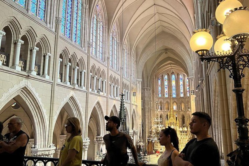 A cathedral interior with arched windows and a high ceiling. 2