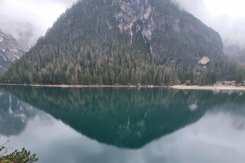 Un lago tranquilo que refleja una montaña boscosa. 2