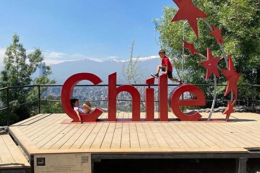 Eine Holzplattform mit großen roten Buchstaben, die 'Chile' schreiben, und Sterndekorationen. 3