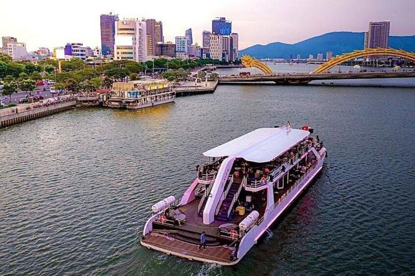 Un río con una embarcación grande, un puente y un paisaje urbano al fondo. 2