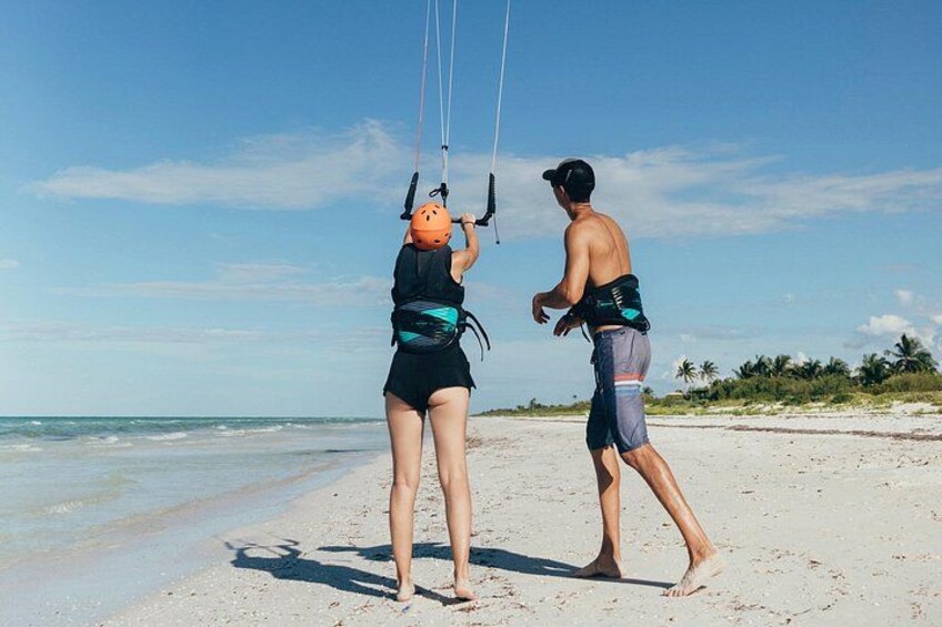 Two people on a beach, one holding a kite. 1