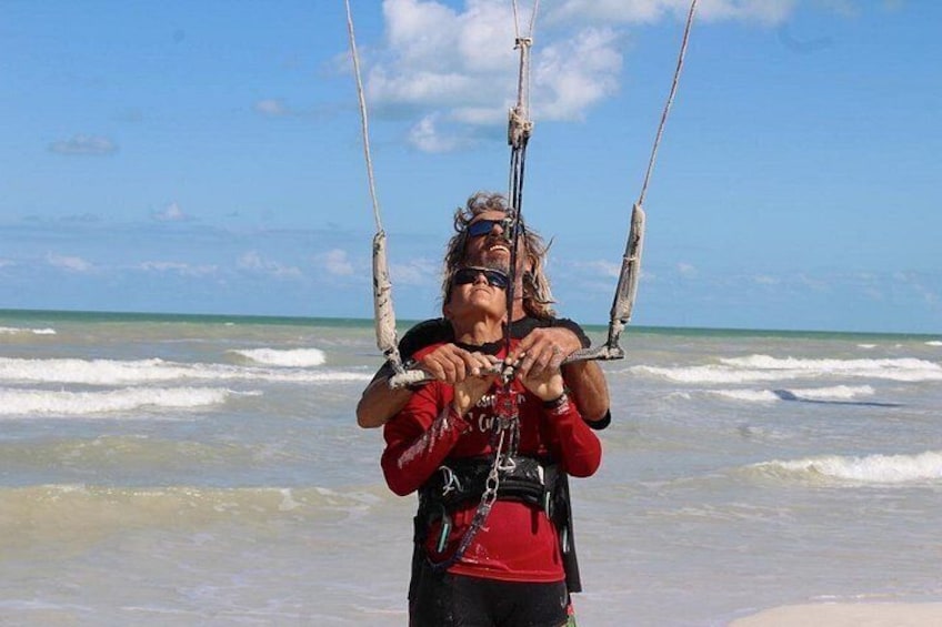Une personne pratiquant le kitesurf sur une plage, avec des vagues en arrière-plan. 5