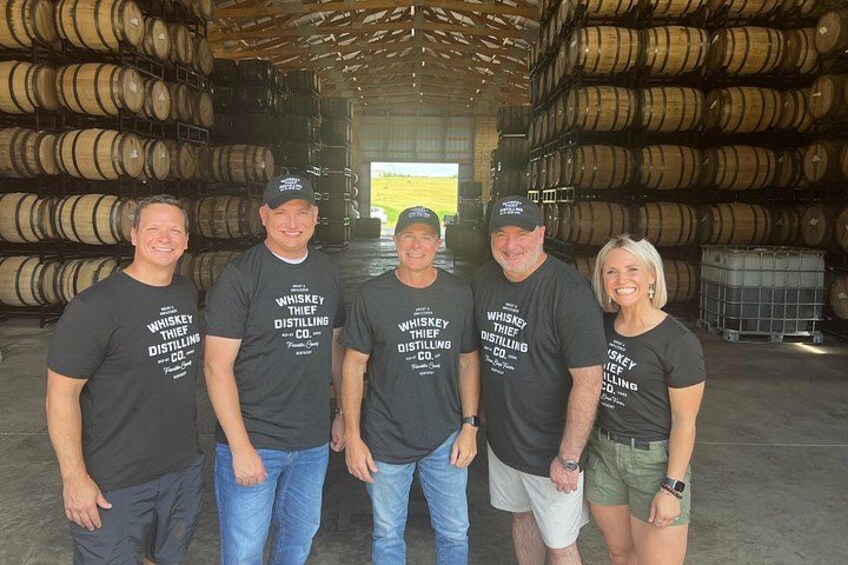 A group of people in a warehouse with barrels. 3