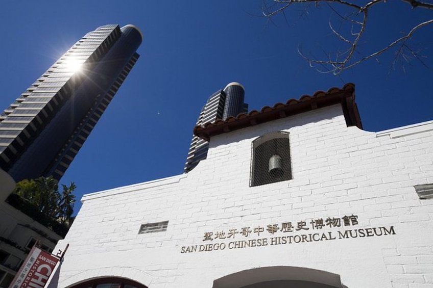 El Museo Histórico Chino de San Diego, con un cielo azul despejado y un edificio alto al fondo. 3