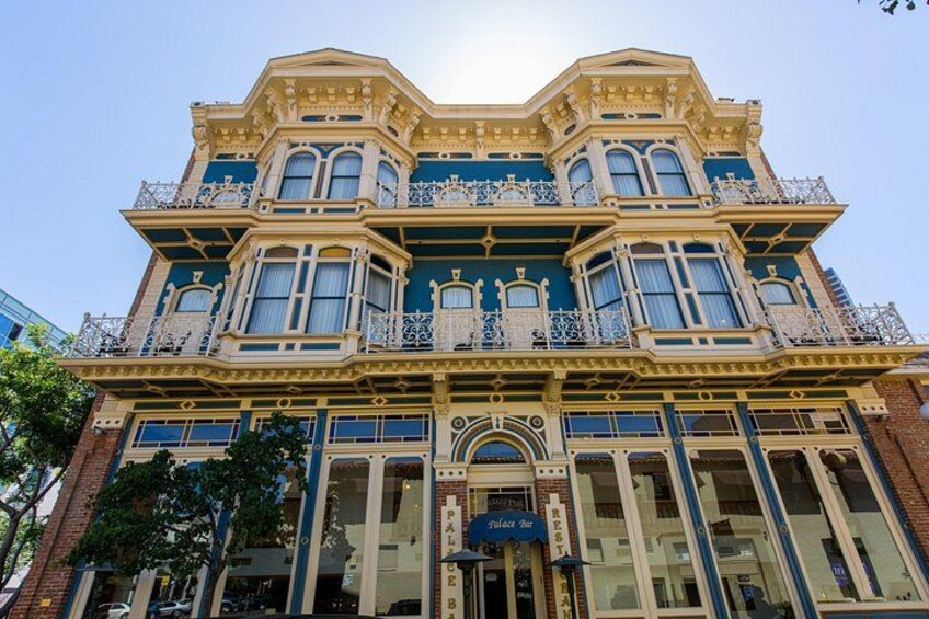 Un edificio grande y ornamentado con múltiples ventanales y balcones, con detalles arquitectónicos intrincados y una entrada destacada. 4