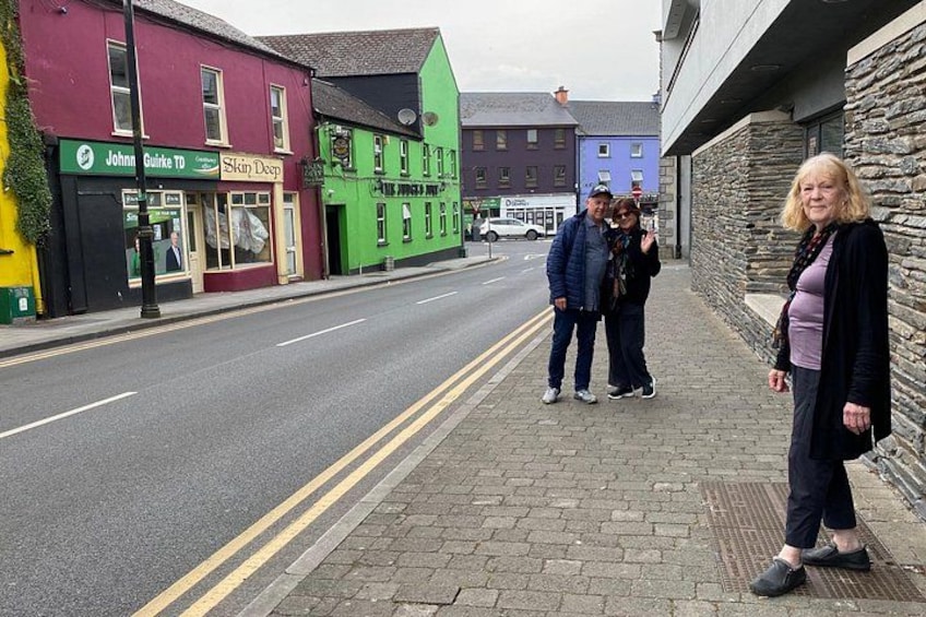 A street with buildings, a road, and pedestrians. 3