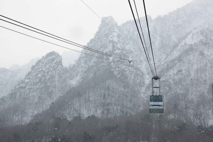A cable car moving through a snowy mountainous landscape. 2