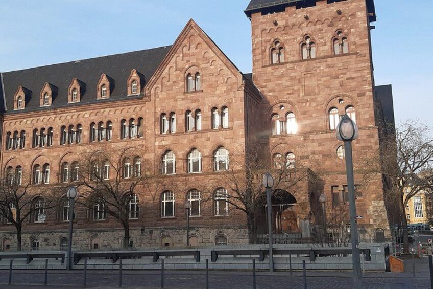 Ein großes Backsteingebäude mit vielen Fenstern und einem Turm. 5