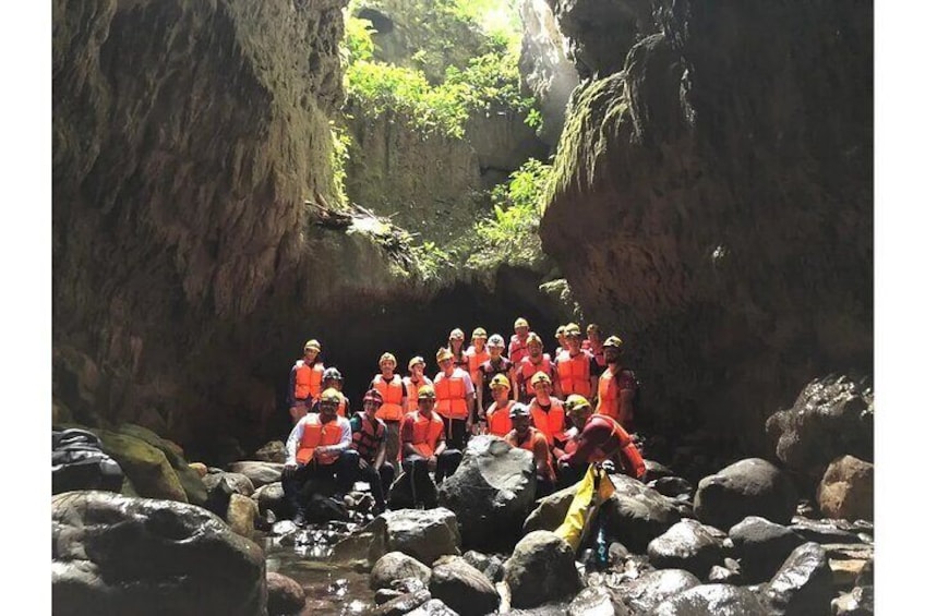 Eine Gruppe von Personen in orangefarbenen Westen hat sich in einer felsigen Höhle versammelt. 5