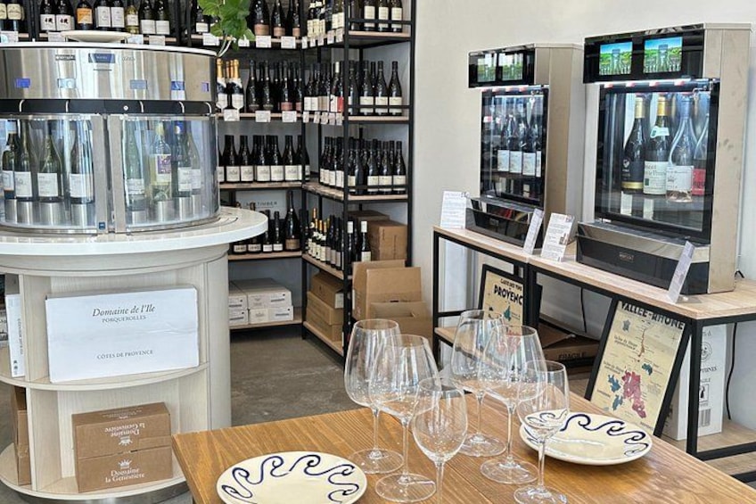 A wine store with shelves of bottles, a display of wine glasses, and signs indicating different wine regions. 2
