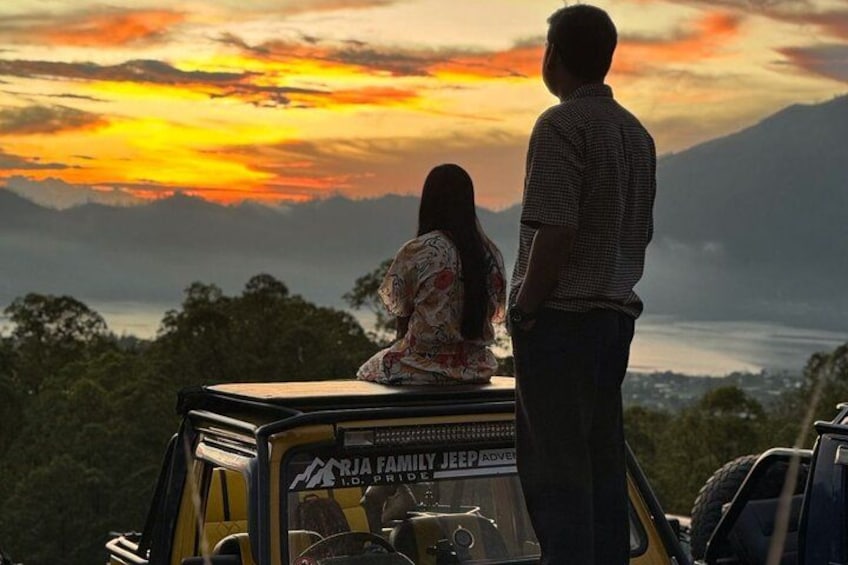 A couple overlooking a sunset with mountains in the background. 4