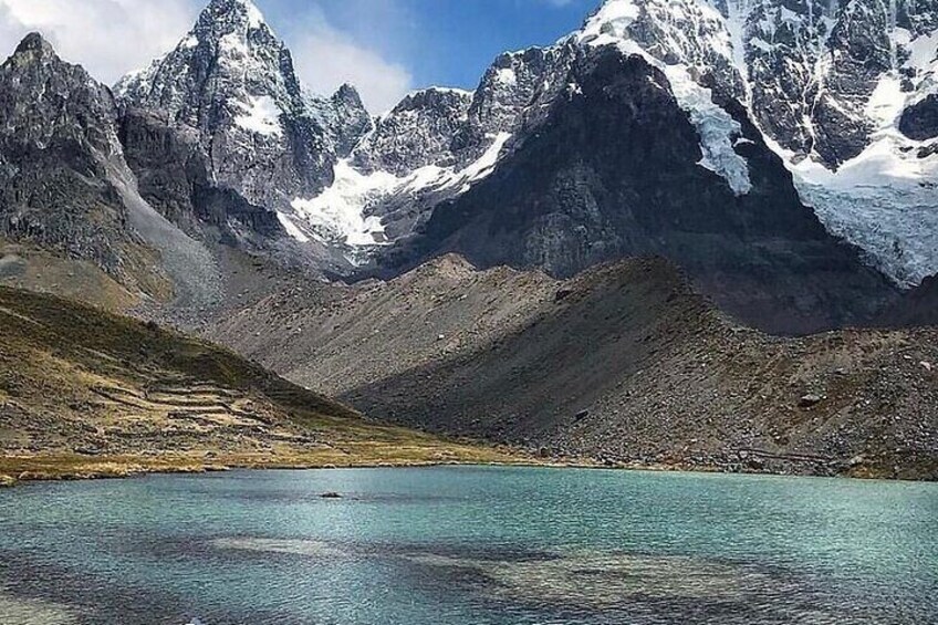 Un lac de montagne entouré de pics escarpés aux sommets enneigés. 4