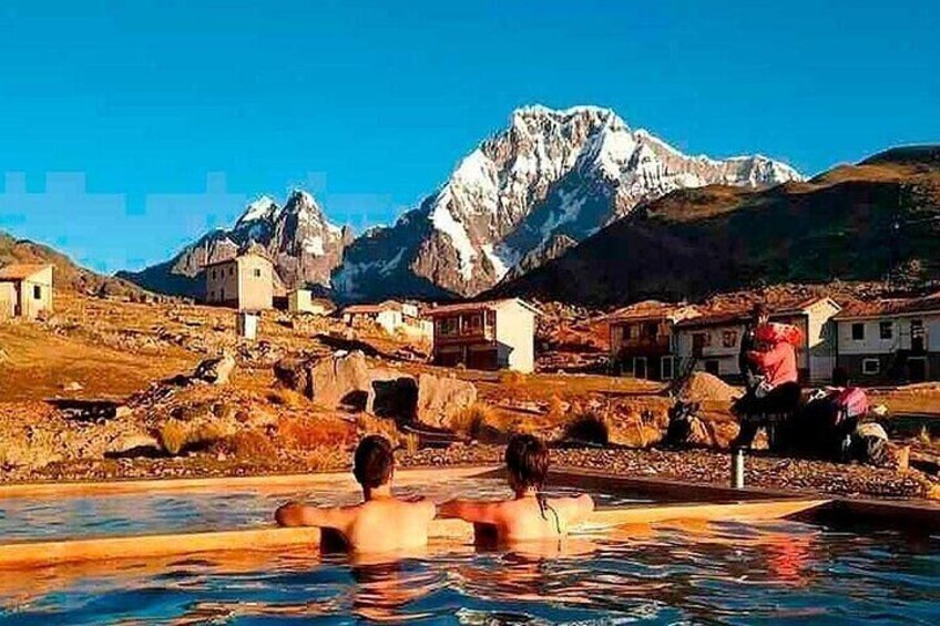 Une piscine où l’on voit des personnes, entourée d’immeubles et de montagnes. 5