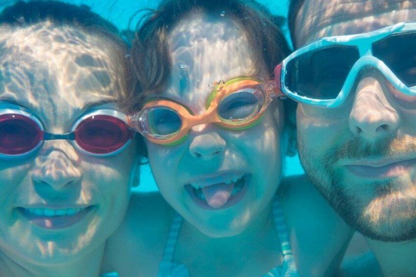 Three people wearing goggles, likely engaged in swimming or snorkeling. 2