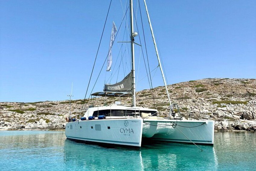 Un yacht blanc, baptisé « CYMA », était amarré près d’une côte rocheuse, dans une eau turquoise et cristalline. 4