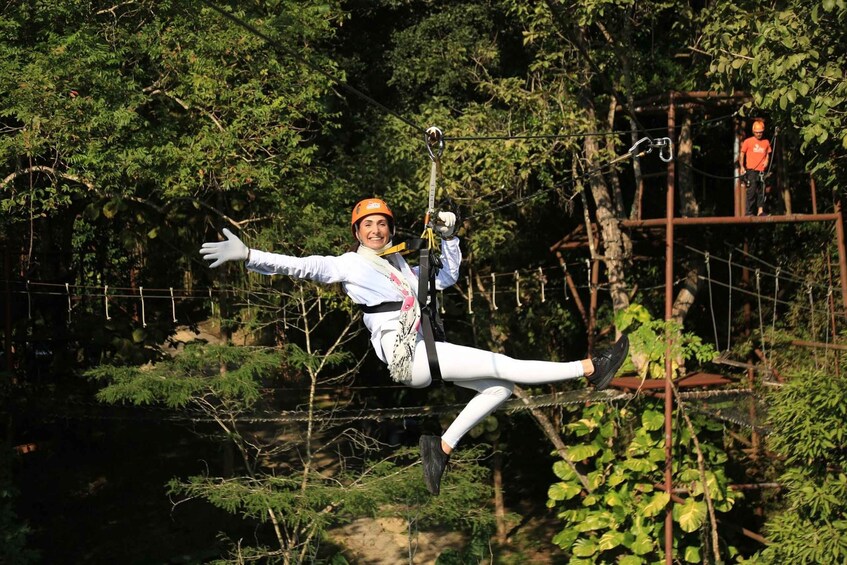 A person ziplining through a forested area with ropes and wooden platforms. 3