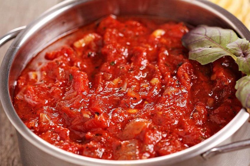 Un pot de sauce tomate avec des feuilles de basilic. 2