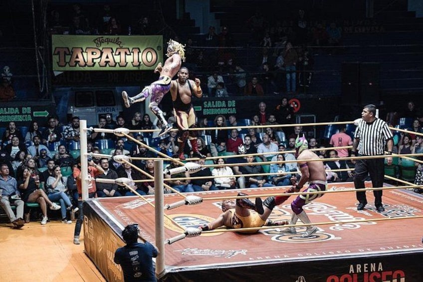 Ein Wrestling-Kampf in der Ringmitte vor einer Zuschauermenge. 2