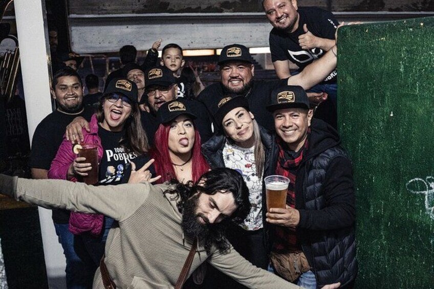 A group of people posing for a photo, some holding drinks. 3