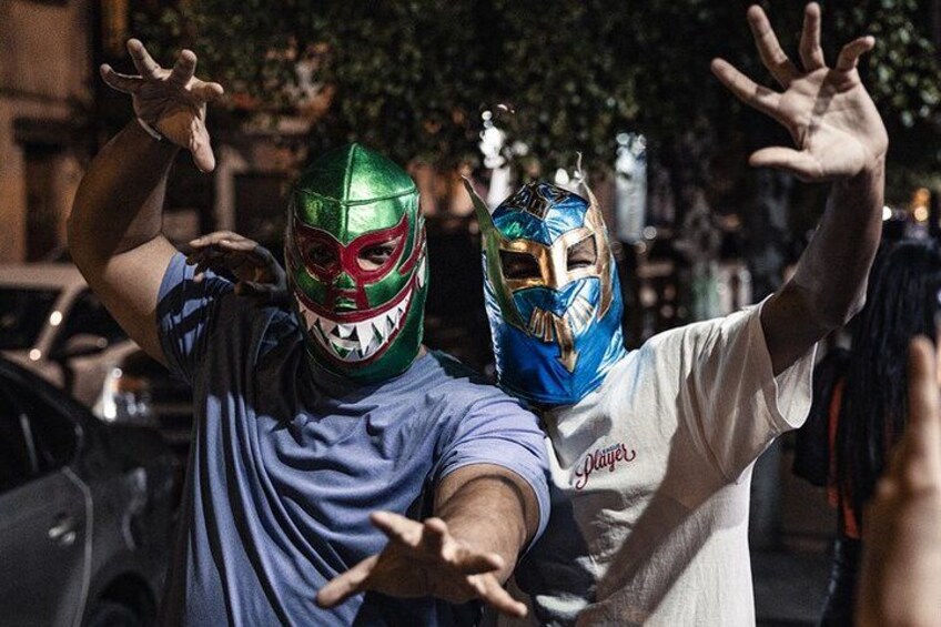 Two people wearing masks with raised hands. 5