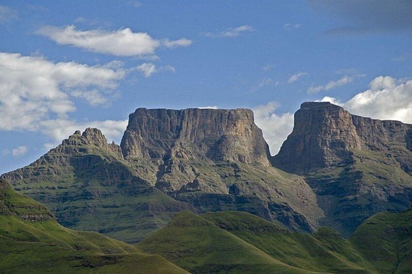 A mountain landscape with prominent cliffs and rolling hills. 2
