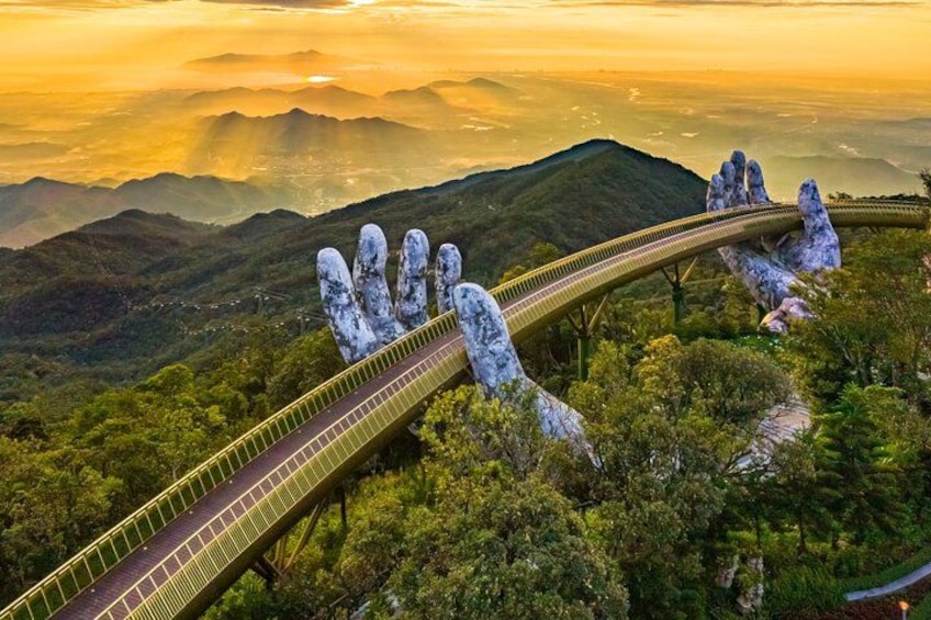 A bridge curving over a mountainous landscape with a unique rock formation resembling a hand. 1