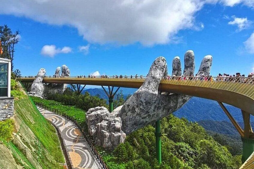 A bridge with large rock formations resembling hands, a winding road, and a mountainous landscape. 3