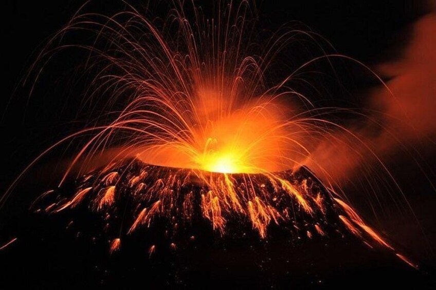 A volcano erupting with lava flowing down its sides. 2