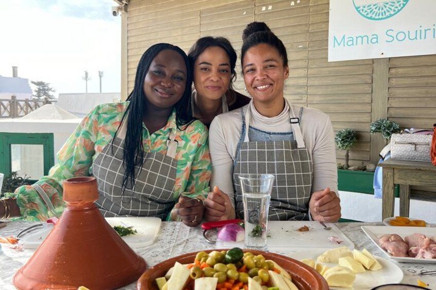 Trois personnes sont assises à une table, devant de la nourriture et un tajine marocain. 5