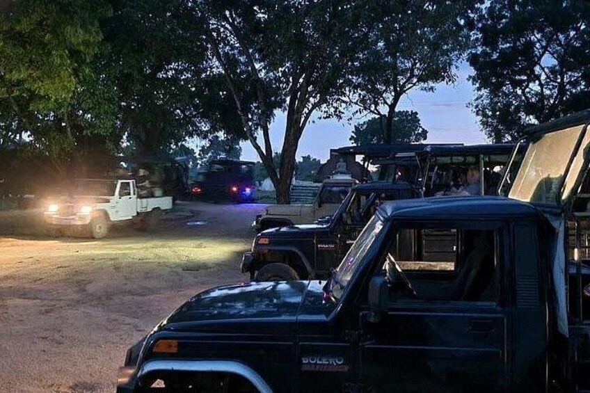 Un'area di parcheggio con diversi veicoli, tra cui un SUV nero e un pick-up bianco. 3