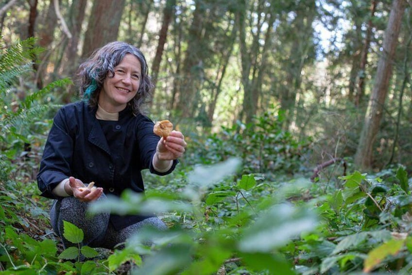 A person in a forest holding a piece of food. 4