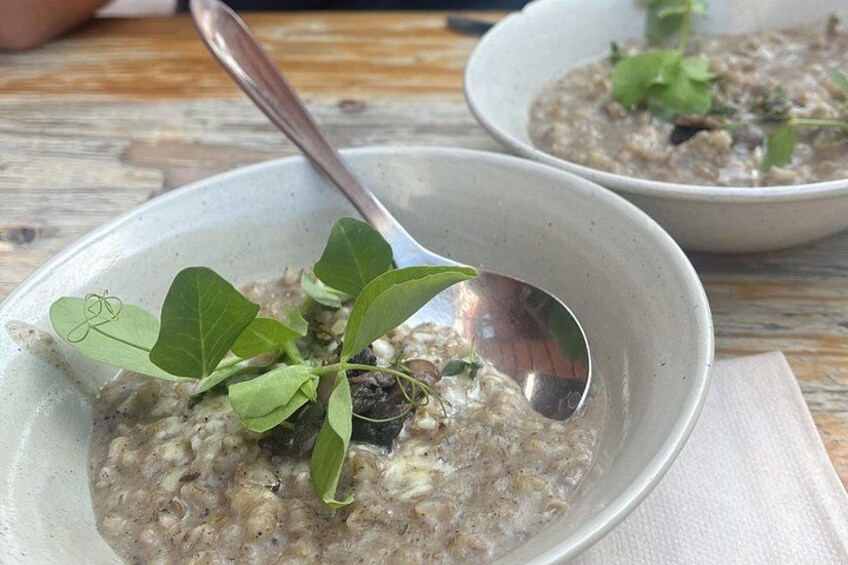 Un tazón de avena con una cuchara y una ramita de hierba verde encima. 2
