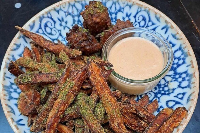 Un plato de okra frita con salsa para mojar y un plato decorativo azul y blanco. 5