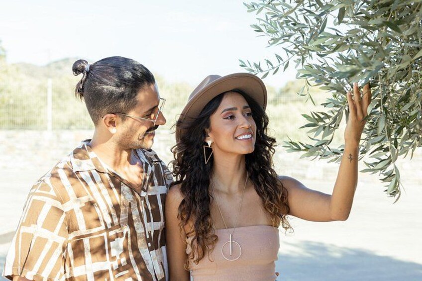 A couple standing outdoors, one wearing a plaid shirt and the other in a hat, with a desert landscape in the background. 5