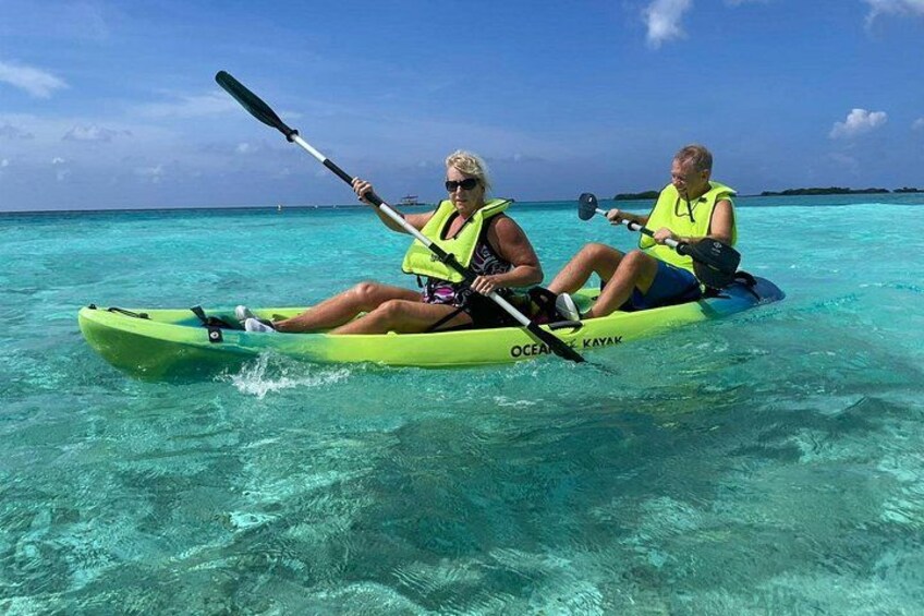 Two people kayaking on turquoise water. 1