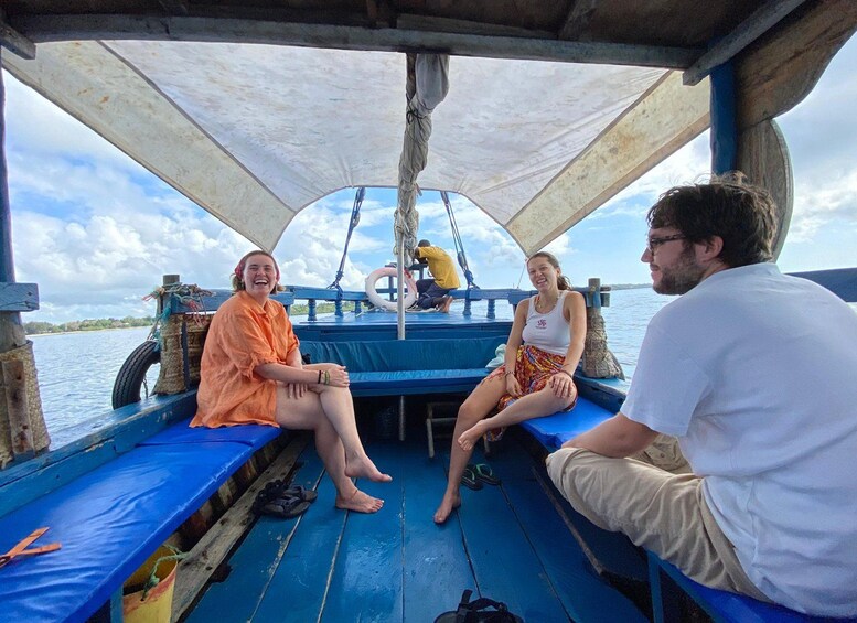 A boat with a blue deck, passengers seated, and a canopy overhead. 2