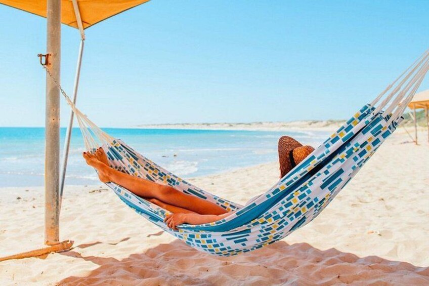Un hamac sur une plage de sable, sous un ciel dégagé. 5