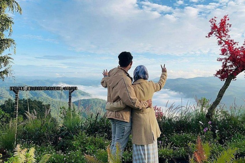 Two people standing on a hill overlooking a valley with a clear sky. 1