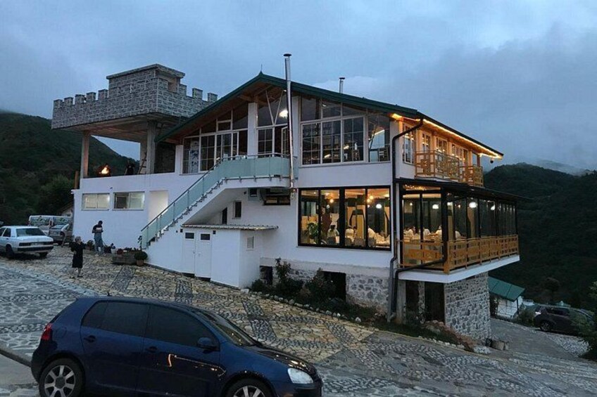 A multi-level building with a stone facade, a balcony, and a staircase. 5