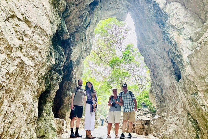 Un gruppo di persone in piedi sotto un arco roccioso naturale. 5