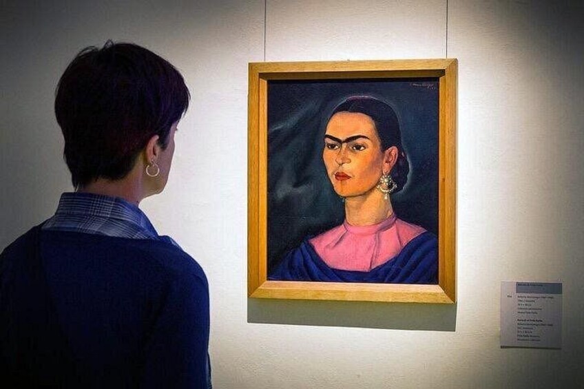 Una persona observando un cuadro enmarcado en una pared. 2
