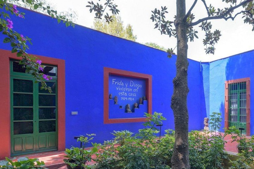 A blue building with a sign that reads 'Frida y Diego vivieron en esta casa 1929-1934.' 2
