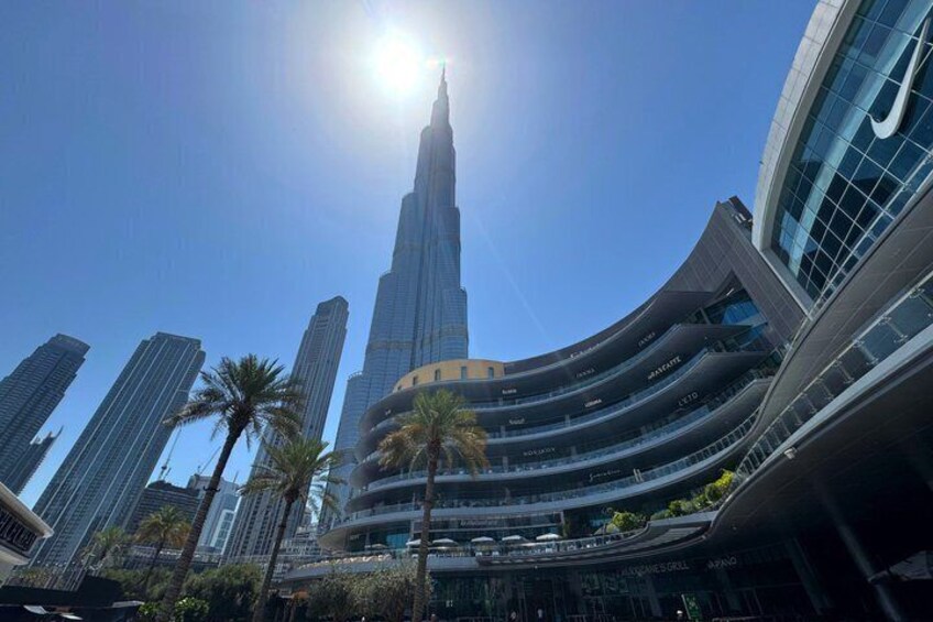 A tall skyscraper with a curved facade, palm trees, and other modern buildings in the foreground. 5